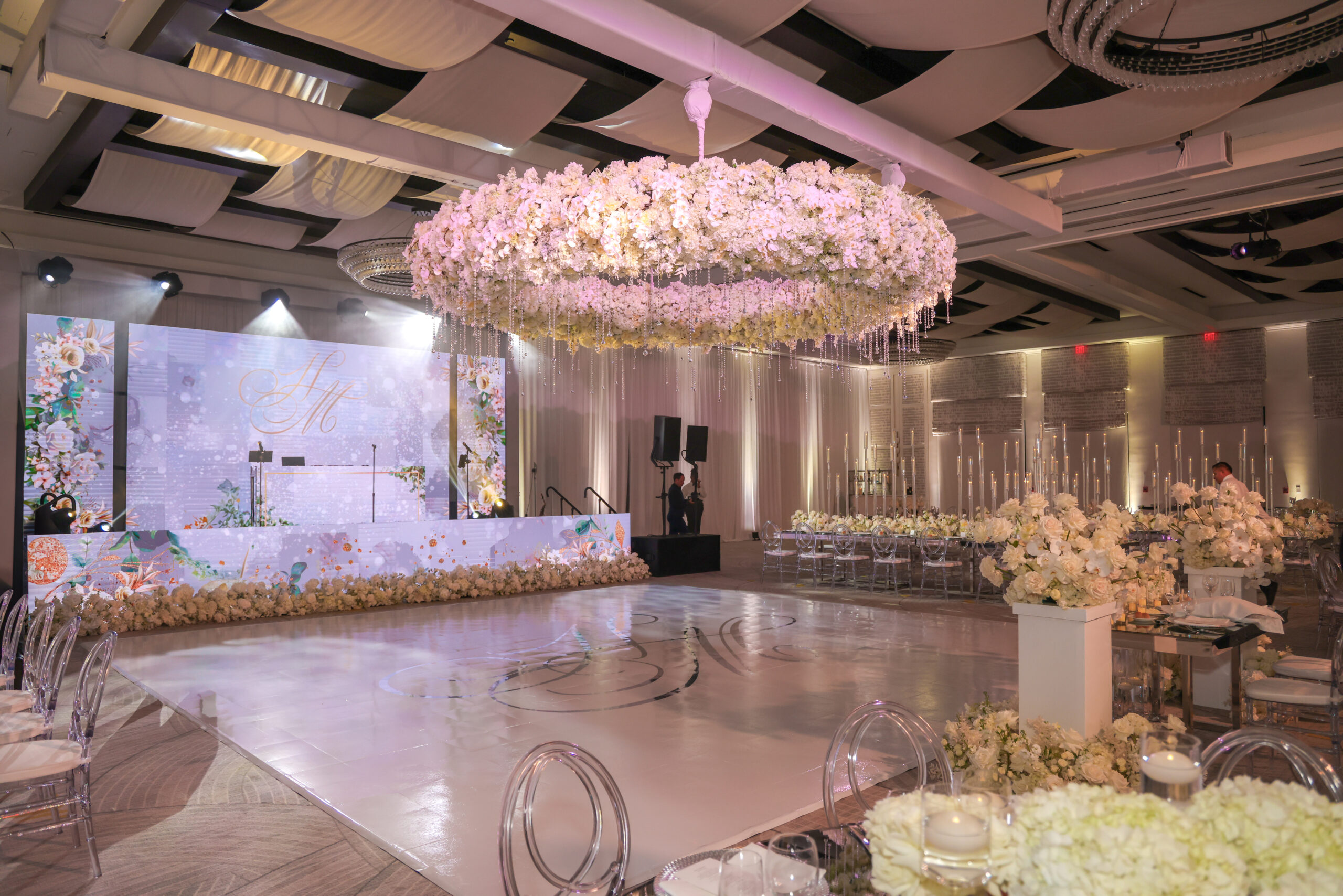 Destination wedding ceremony with pure white florals and ghost chairs Grand Cayman